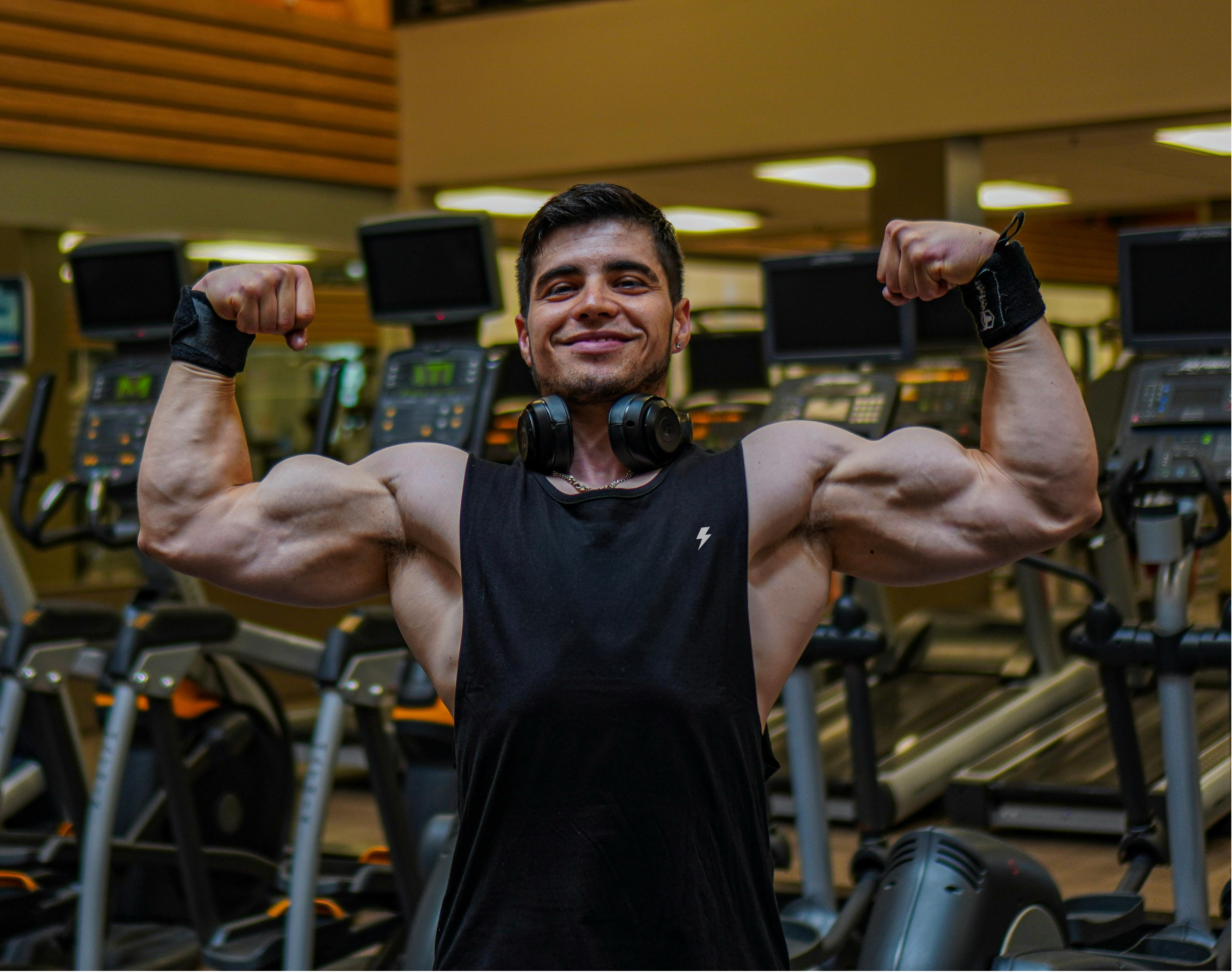 Man flexing muscles in a gym setting